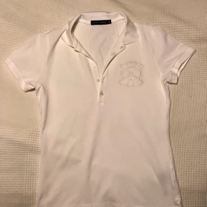  - Vit RALPH LAUREN piké i strl M. Så gott som oanvänd och ordinarie pris var 800kr.