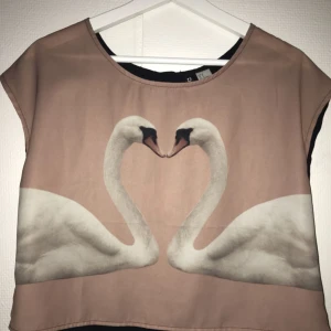  - Superfin magtröja med svanmotiv framtill å knappar baktill! Luftig och skön under sommaren. Oanvänd😊