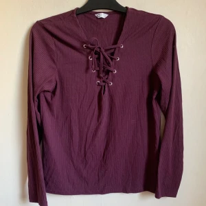 Topp från Cubus - Snygg vinröd t tröja från Cubus med flätning framtill. 
