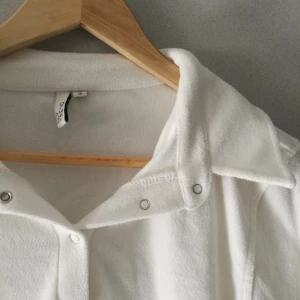 Vit tröja - Snygg och mysig vit tröja från Nelly trend med knappar framtill, inte mkt använd. 