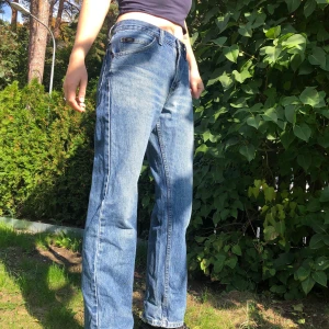 Jeans från Lee  - Snygga ljusa low waisted jeans från Lee. Jättebekväma och snyggt slitna. (Finns ett litet hål på rumpan som i princip inte syns) Lägg ett bud :) 