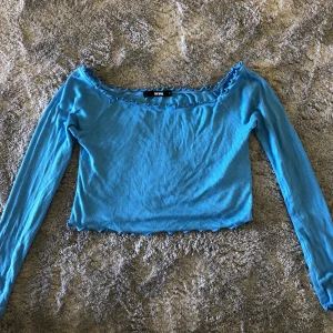 Off shoulder tröja från BIKBOK - Jättefin blå off shoulder tröja från BIKBOK! Är i storlek M men passar på mig som i vanligt fall har S. Fina detaljer där uppe, nere och på ärmarna🥰  använd 1 gång. 150 kronor + frakt 44 kr. Priset kan diskuteras. 