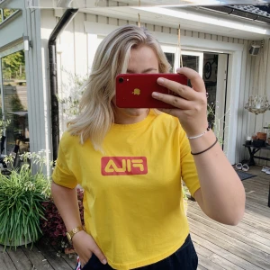 FILA T-shirt  - Säljer denna gula FILA T-shirt då den aldrig kommer till användning. Den är croppad (går till byxkanten). Är i storlek L men är liten i storleken så skulle säga att den är M. Aldrig använd så den är i väldigt fint skick. 50kr + frakt!🥰