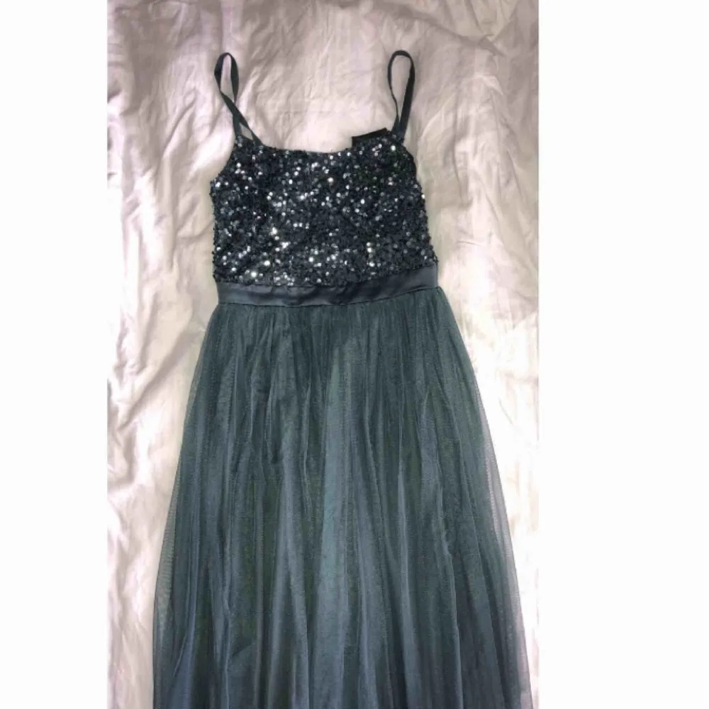 Grön/blå/grå klänning som jag använt 1 gång på min bal, fint skick, jag är 180cm och klänningen gick precis ner till marken. Nypris 999kr . Klänningar.
