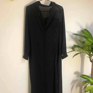  - Svart lång klänning i mesh. Knappar hela vägen ner. 