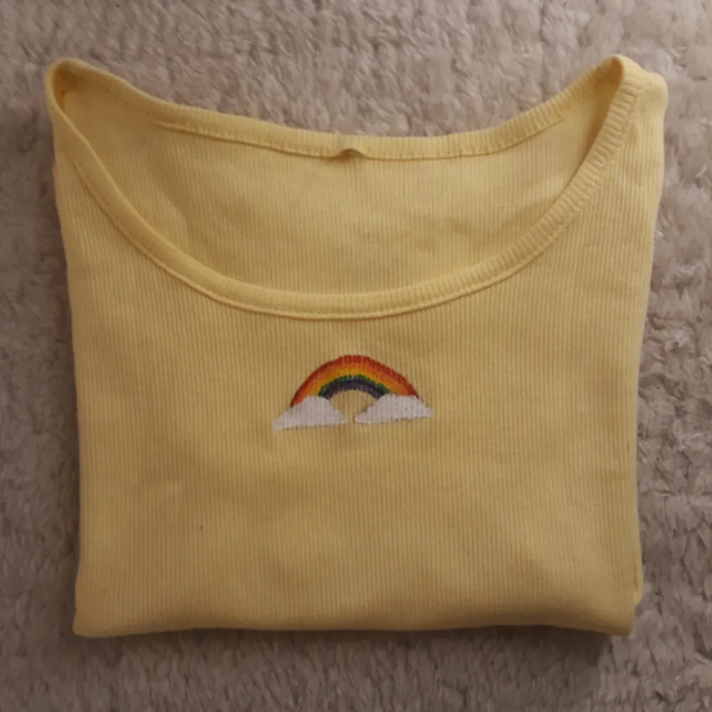 Ljus gul t-shirt med korta ärmar och en målad regnbåge. Den är lite genomskinlig därav priset. Fråga om du har nån eller  vill ha mer bilder😋🌈  Tvättas i 40°C. T-shirts.