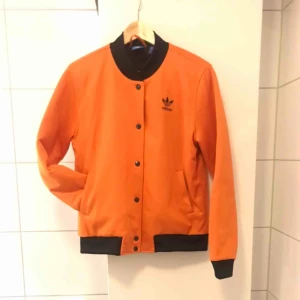  - Orange adidas bomberjacka inköpt för 2 somrar sen- sparsamt använd så den är i nyskick. :)  Kan skicka eller mötas upp i Stockholm.  Nypris 900:- 