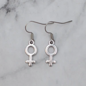  - Fina silverfärgade örhängen med kvinnosymbolen. Finns även som guldfärgade. Nickelfria. Fri frakt vid köp över 100:-.