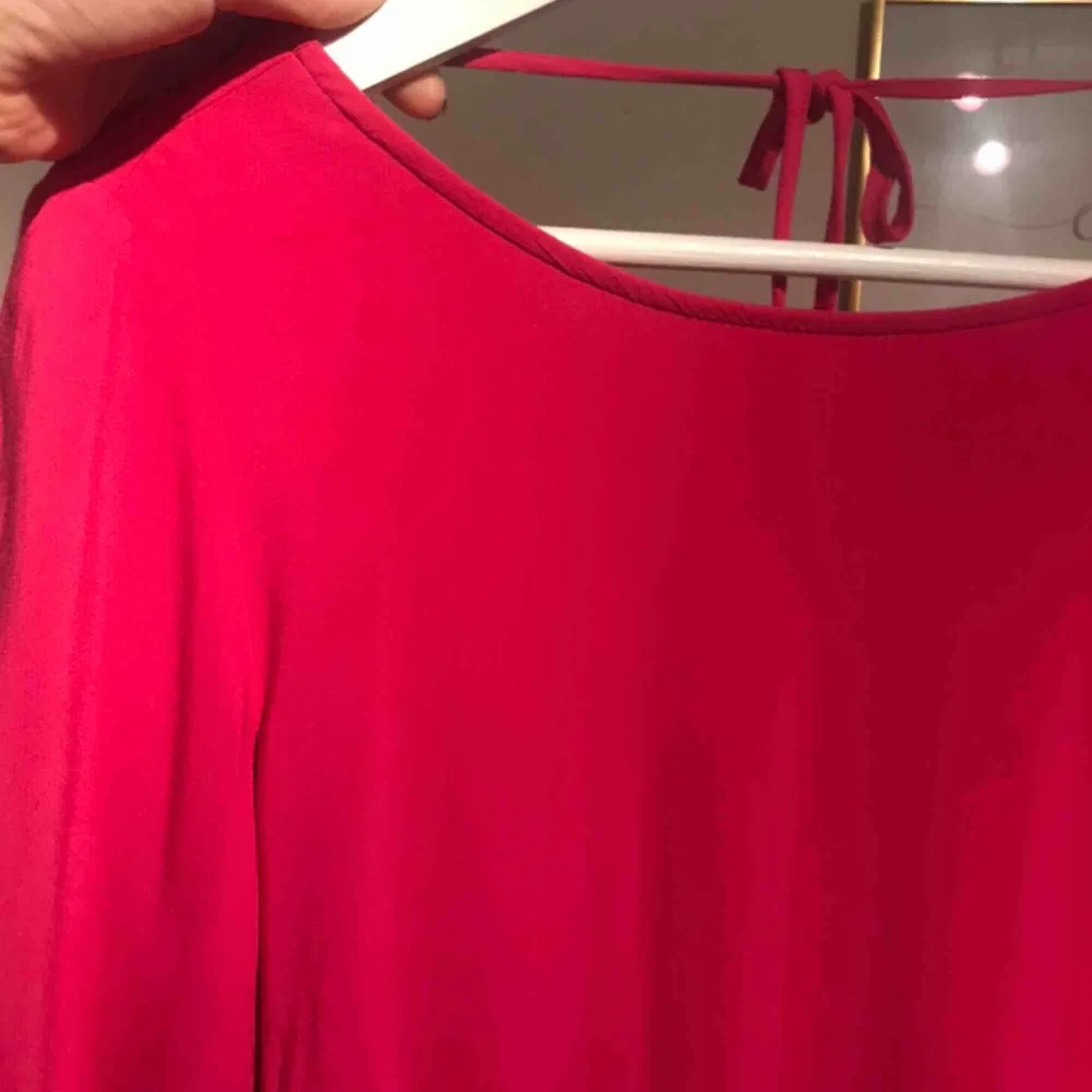 En tunnare klänning men urringning i bak.  Klänningen är rosa, ej åt det röda hållet. Klänningar.