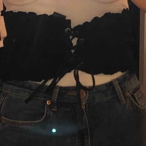  - En mjukare svart korsett som är en snygg detalj till vanliga toppar.