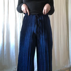 Blåa plisserade sammetsbyxor - Skitsnygga plisserade sammetsbyxor från Urban Outfitters.✨ Använda ytterst få gånger och säljer på grund av det. Extremt sköna att mysa i men kan också klä upp dom! Köparen står för frakt 💙