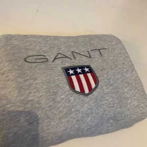 Gant Hoodie  - Säljer denna snygga Hoodie från GANT eftersom att den inte kommer till andvänding. Storlek 158/164 men är ganska stor i storleken, är ungefär som en XS/S. Endast andvänd 1 gång därav jättefint skick och nästintill ny, inga fläckar eller slitningar. Köpt för 800 och säljer för 400. Hör av er vid intresse! 