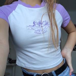 Jättesöt croppad t-shirt med lila änglatryck från shein. Säljer då den knappt kommer till användning. Inga fläckar eller skador. Frakt tillkommer❣️
