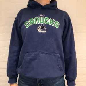 Vintage Hoodie Canucks  - Vi säljer denna blå hoodie med broderat Canucks på. Priset är 329kr.  Den har ingen storlek men passar som en S. Personen på bilden är 175cm och brukar ha på sig S/M. Lite blekt i färgen över fickan men syns knappt. Inga defekter utöver det.                    Kontakta oss på Plick eller vår Instagram @wanderetro. Om flera visar intresse blir det budgivning. Köparen står för spårbar frakt på 66kr. 🤍