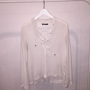  - Fin blus med snörning och urringad! Snörning en är fin eftersom det är "grova" snören och den är fin i kragen och ärmarna är vida längs ut! BILLIGT 