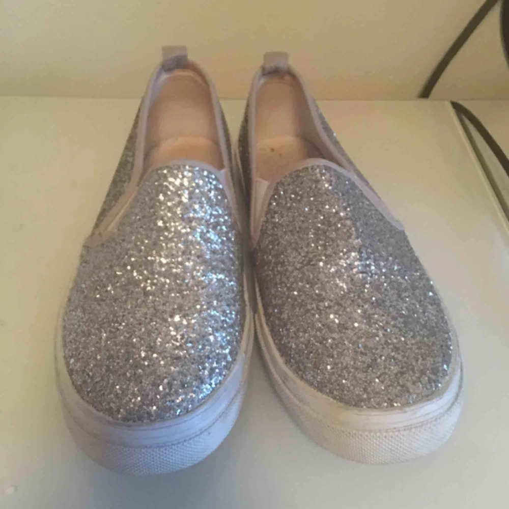 Ett par silver glittriga skor från HM.  Kan mötas upp i centrala Stockholm, köparen står för frakten . Skor.