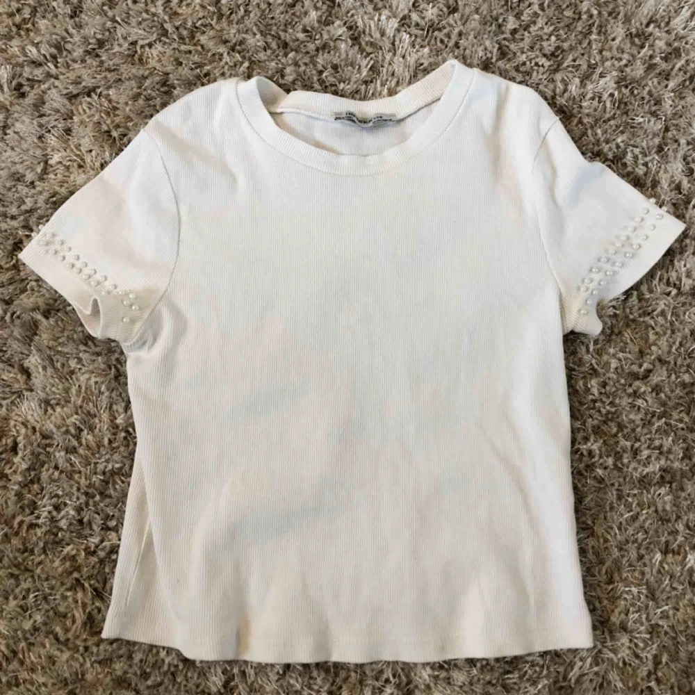 Vit T-shirt med randigt tyg från Zara, har använt den ganska mycket förut men nu är den tyvärr för liten för mig. Köparen står för frakten✨. T-shirts.