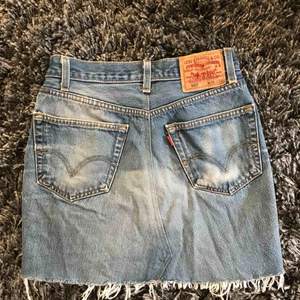 Jeanskjol ifrån Levis. Står W36 i den men tycker den passar storlekar S/M. Slitningar längst ner och kjolen är i mycket fint skick