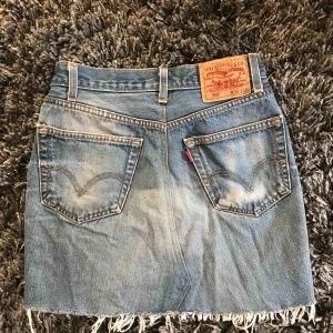  - Jeanskjol ifrån Levis. Står W36 i den men tycker den passar storlekar S/M. Slitningar längst ner och kjolen är i mycket fint skick