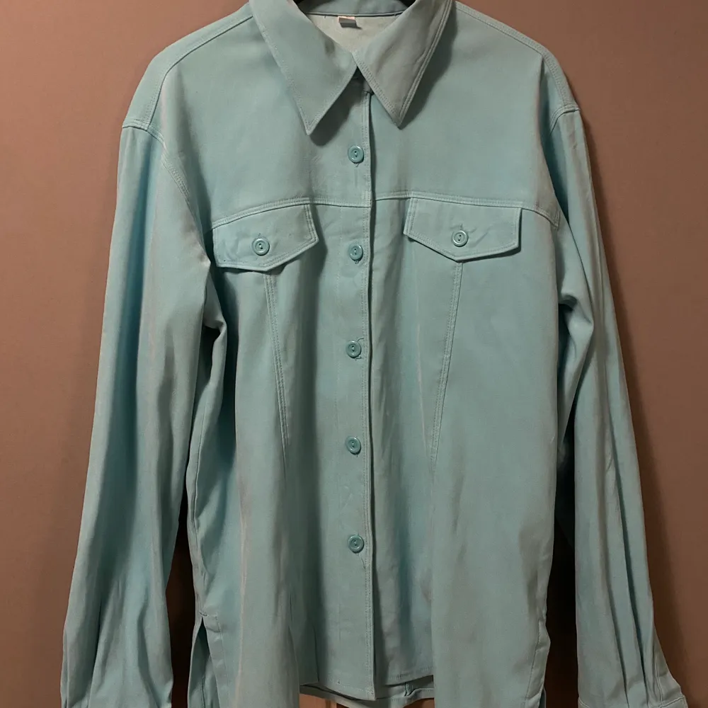 Säljer denna ljusblå/gröna overshirt/skjortan, den har en snygg spetsig krage med två fickor över brösten. . Skjortor.