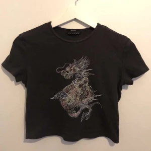 croppad t-shirt med motiv - En fin croppad t-shirt med en drake som motiv. Köp nu! 🪐