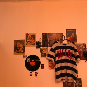 Randig Dallas T-Shirt - En vit och mörkblå randig t-shirt med ”Dallas” tryck på framsidan. Köpt på H&M i storlek XL. Använd ett fåtal gånger och säljer för att jag behöver pengarna. Säljer för 50kr + frakt:)