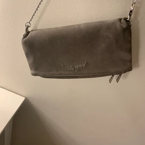 Zadig väska - Säljer min gråa Zadig väska i suede. Köpt på Zadig affären i Stockholm. Köptes för cirka 3000 kr. Köpare står för frakten