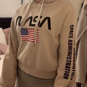 Beige hoodie med NASA märke