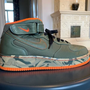 Nike Air Force 1 High  - Hej! Efter en lång dag av kläd- och skorensning så kommer jag sälja dessa superfina AF-1 ’82 .  De är ett par militärgröna sneakers med inslag av orange. De ser nästintill oanvända ut och jag skulle säga att skicket ligger på 9/10. Likea/Kommentera vid intresse! Håll utkik, fler skor kommer inom kort! :)