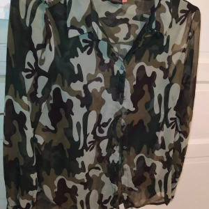 Snygg transparent camo skjorta med nitar 38 - Strl 38. I jättefint skick! Stjärn-nitar. Frakt tillkommer på 44:- samfraktar gärna! Djur och rökfritt hem.