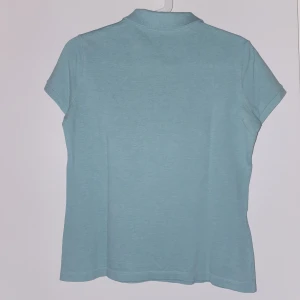 Lacoste - En Lacoste piké i storlek S. Knappt använd