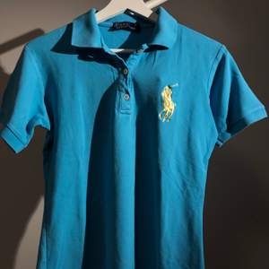 Polo T-shirt i blå, storlek XL, skulle säga den passar en 13 åring, fint skick, trevlig somrig blå färg.