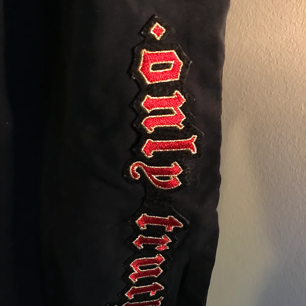 Dark blue upcycled windbreaker joggers with a sewn side slit and two patches. Drawstring waist, puma patch on right thigh, ONLY TRUTH patch on left leg. . Jeans & Byxor.