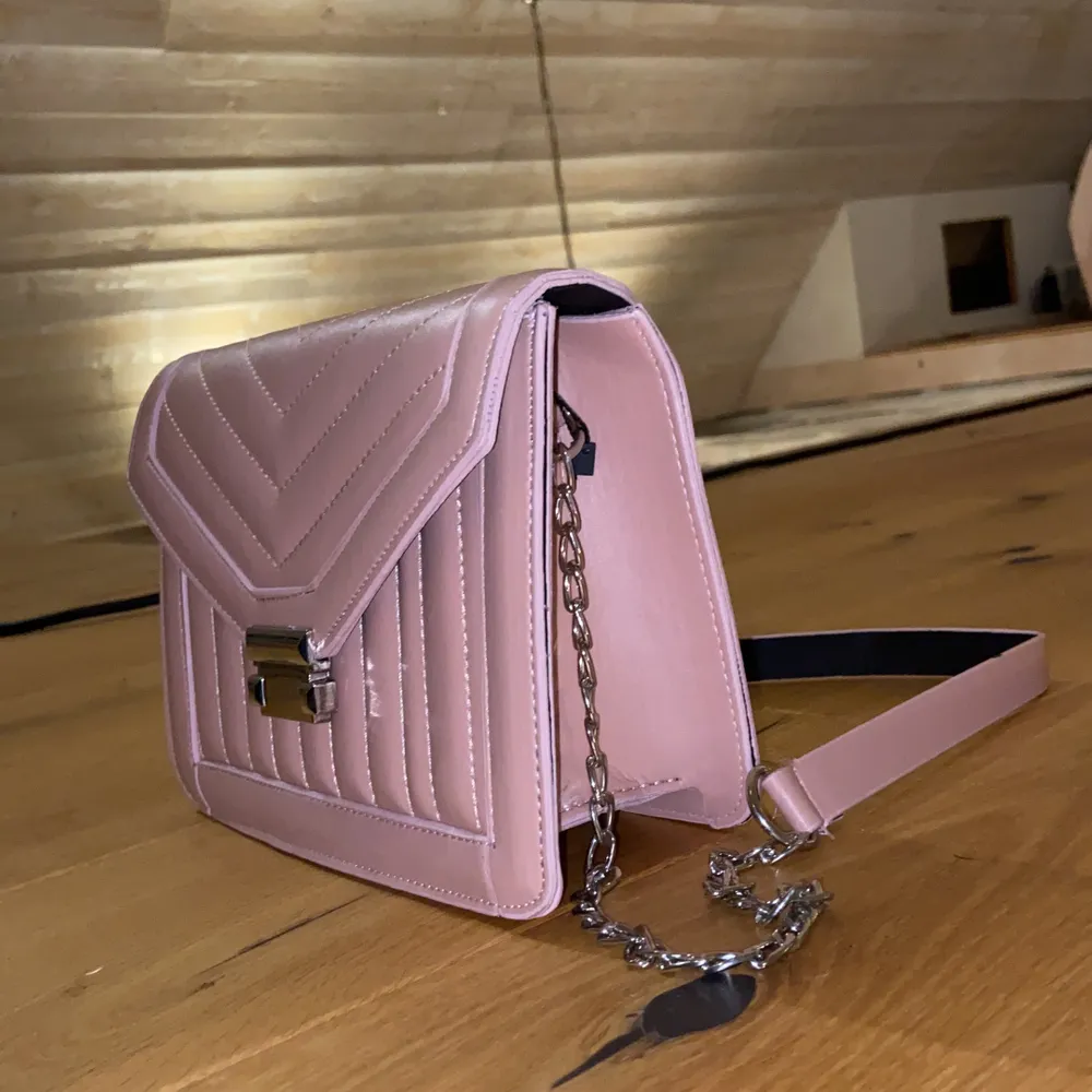 En super fin rosa handväska som inte har kommit till någon användning för mig tyvärr. Den är helt ny, lappen sitter kvar!. Väskor.