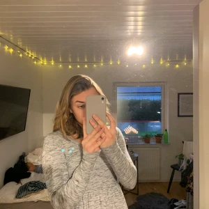 Grå stickad blus/tröja med guld detaljer  - Grå stickad v ringad tröja med guld detaljer.💕