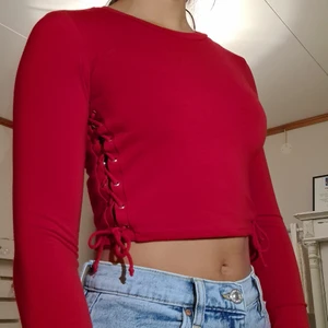 Röd croptop - En supersnygg röd croptop med snörning på sidorna🤍 Märket är Forever 21 och den är i strl M. Använd ca 2 ggr. Frakt 22kr🥰