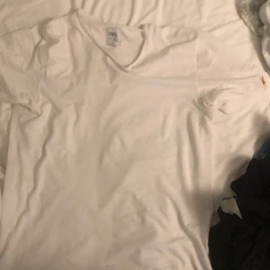 Vit T-Shirt  - Finfin Zara T-shirt av högsta kvalitét, tillverkad i ”högtidsutstyrselns Mekka” Bangladesh! Storlek L, har en liten chokladdfläck på vänster arm, går kanske bort i tvätten, fan vet jag. Har inte orkat tvätta själv 