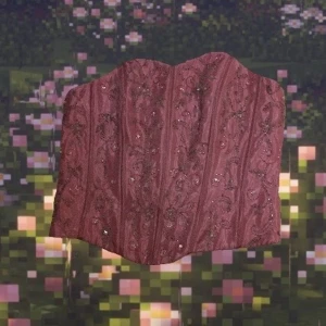 Rosa korsett top - Jättefin rosa korsett top med mönster av pärlor i ett glansigt material💕 Toppen har ingen ihopsnörning, istället stänger man med en dragkedja som sitter på ryggen! Den finns ingen lapp, men den passar s och medium bäst.                                      Jag kan mötas upp i Stockholm och annars står köparen för frakten🥰 