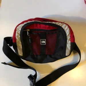 - Äldre midjeväska / Fanny pack från The North Face i trevligt använt skick. Två fack med dragkedja. Hämtas i Uppsala eller skickas mot fraktkostnad
