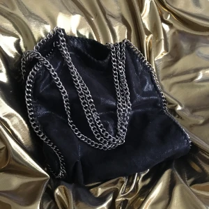  - En rymlig och fin svart väska från Nelly svart med silver kedja (en bit av kedjan har lossnat ser man på bild 3) perfekt för skolan! Skriv vid intresse eller för mer bilder kan möttas upp på Södermalm eller posta (köparen står för frakten)