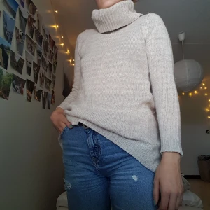  - Stickad polotröja i en natur beige färg. Supermysig krage och unik skärning nertill. Stl S. Frakt tillkommer.