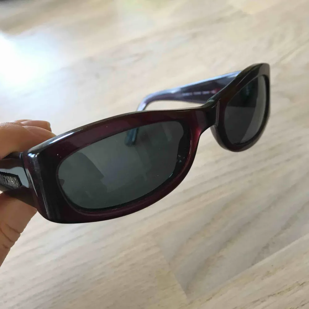 Snygga solglasögon från Moschino i en väldigt mörkröd, nästan svart, färg. Glasen är lite tonade i blått. Har inte kommit till användning. Begagnat fint skick. Accessoarer.