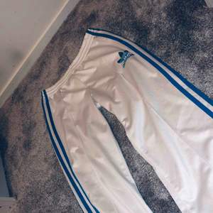 vita Adidas byxor med blåa streck, dom har en lite fläck där bak (se bild) har inte testat å tvättat så kanske går bort annars mkt fint skick✨