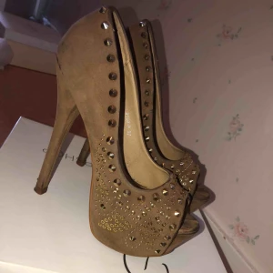 - Beigea Fina pumps me öppen tå och guld nitar som en extra piff. Klackhöjden är 15cm, men eftersom skorna her en högplatå är dom sköna att gå i! 