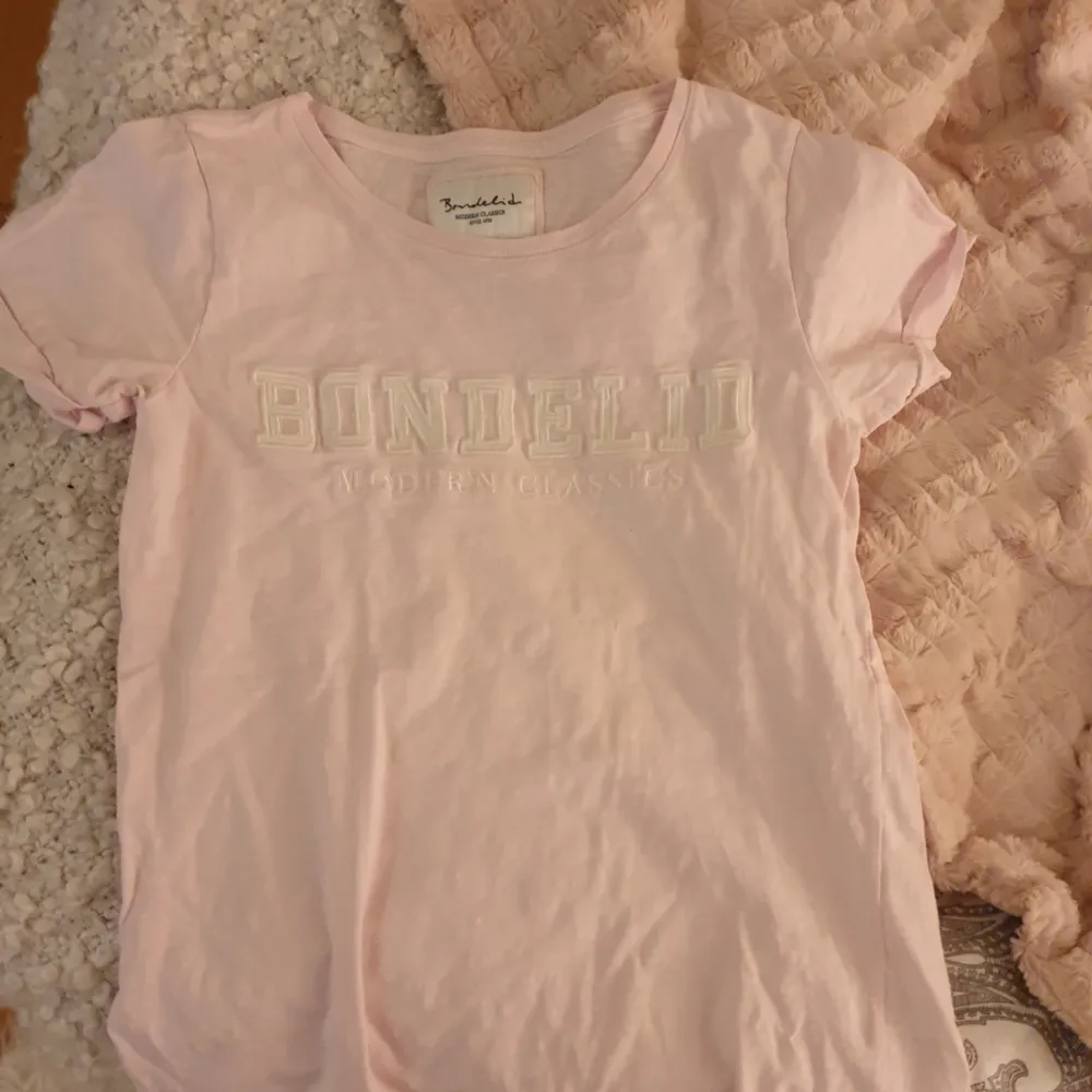 Oanvänd bondelid t shirt i en fin rosa färg . Övrigt.
