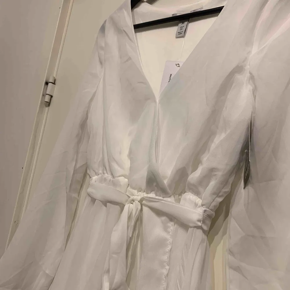 •vit klänning med delvis tyll •reglerbart band i midja •resår midja •transparent ärm •oanvänd med prislapp kvar. Klänningar.