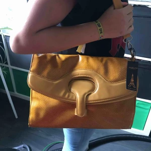  - Ny handväska i lejongult m krocko/ orm-prägling. Köpt utomlands Köparen står för frakt 