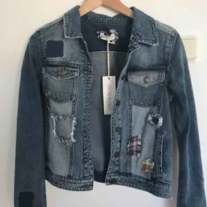 Blå jeansjacka med detaljer i form av påsydda ”lappar”. Aldrig använd. Köpt från asos. Köparen står för frakt. 